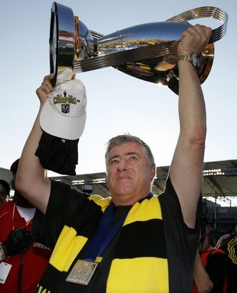 Columbus Crew's head coach Schmid holds up the Philip F. Anschutz trophy as he celebrates on the field after defeating the New York Red Bulls to win the 2008 MLS Cup soccer final match in Carson